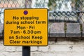 A street sign tells drivers no stopping during term time on keep school clear markings