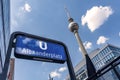 Street sign from U Bahn, Alexanderplatz in Berlin, taken from a low point of view. In the background the famous television tower a