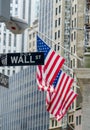 Road sign of wall street against US flag in horizontal view