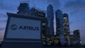 Street signage board with Airbus logo in the evening. Blurred business district skyscrapers background. Editorial 3