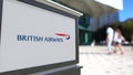 Street signage board with British Airways logo. Blurred office center and walking people background. Editorial 3D Royalty Free Stock Photo