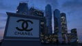 Street signage board with Chanel logo in the evening. Blurred business district skyscrapers background. Editorial 3