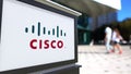 Street signage board with Cisco Systems logo. Blurred office center and walking people background. Editorial 3D