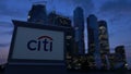 Street signage board with Citigroup logo in the evening. Blurred business district skyscrapers background. Editorial 3D