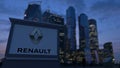 Street signage board with Groupe Renault logo in the evening. Blurred business district skyscrapers backgroun