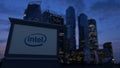 Street signage board with Intel Corporation logo in the evening. Blurred business district skyscrapers background