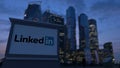 Street signage board with LinkedIn logo in the evening. Blurred business district skyscrapers background. Editorial 3