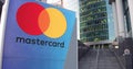 Street signage board with MasterCard logo. Modern office center skyscraper and stairs background. Editorial 3D rendering