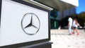 Street signage board with Mercedes-Benz logo. Blurred office center and walking people background. Editorial 3D