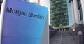 Street signage board with Morgan Stanley Inc. logo. Modern office center skyscraper and stairs background. Editorial 3D