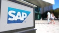 Street signage board with SAP SE logo. Blurred office center and walking people background. Editorial 3D rendering