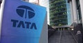 Street signage board with Tata Group logo. Modern office center skyscraper and stairs background. Editorial 3D rendering