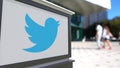 Street signage board with Twitter, Inc. logo. Blurred office center and walking people background. Editorial 3D