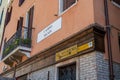 Street corner in Venice, Italy on narrow alley with view of plants and doorway.