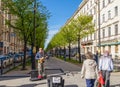 A street singer performing guitar and singing with people passing by at the corner in the Nevsky Avenue, St. Petersburg