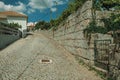 Street on a slope with stone wall and iron gate