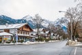 street of a small Alpine town and ski resort with typical houses, road and mountains Royalty Free Stock Photo