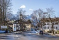 Street of a small Alpine town and ski resort with typical houses, road and mountains Royalty Free Stock Photo