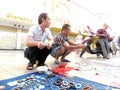 The street stall, selling old books and ancient coins. People are watching, and buying