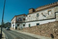 Street with stone wall and old white houses