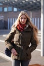 Street style fashion portrait of young woman waiting at bus station Royalty Free Stock Photo