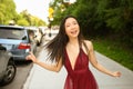 Street style outdoor portrait of Beautiful young Chinese Asian happy smiling woman walking outside sunny summer day Royalty Free Stock Photo