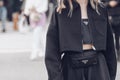 Street style, woman wearing denim jacket, a high waist black midi skirt, a black handbag from Prada, black socks, black pointed