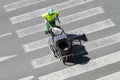 Street sweeper pushing a cart on crosswalk