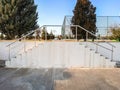 Street symmetrical white cement staircase with metal handrails