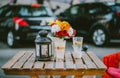 A street table with flowers and a glass