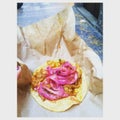A street taco with pink onion