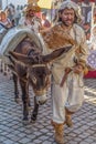 Street theater spectacle show, with actors walking the streets dressed in middle-aged costumes and holding donkeys also decorated