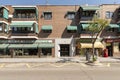 Street with three-storey houses with awnings on the terraces