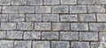 Street tiles are rectangular. Paved street or pavement, city street decoration in retro or vintage style. Gray stone or brick wall