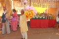 Street trading. Indian seller of street food in yellow clothes. India, Goa, Anjuna. Market or bazaar