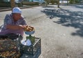 Street trading poor retired grandmother in hot sun