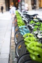 Electric bicycles with baskets for public rent stand on street in Paris waiting for cyclists Royalty Free Stock Photo