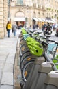 Popular bikes for public rental stand at parking station on street in Paris ready for use Royalty Free Stock Photo