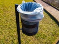Street trash bin with blue sack.