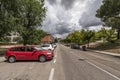 A street with an urban park on one side and cars battery