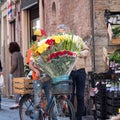 Street Vendor Carrying Flowers on a Bicycle and Offering them for Sale to a Man on a City Street