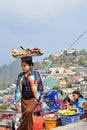 A street vendor carrying tray of freshly cooked yam, cassava and alike on her head Royalty Free Stock Photo