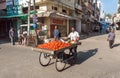 Street vendor with cart full of tomatoes selling vegetables on street of indian city