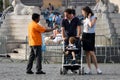 Street vendor and couple with child in stroller