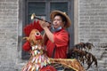 GUANGZHOU, CHINA Ã¢â¬â CIRCA JUNE 2020: Street vendor in Guangzhou dressed up as a colorful rooster.