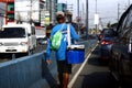 Street vendor peddle snack items and cold water to drivers stuck in traffic