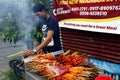 Street vendor sell assorted grilled pork and chicken innards barbecue at his makeshift food stall