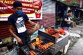 Street vendor sell assorted grilled pork and chicken innards barbecue at his makeshift food stall Royalty Free Stock Photo