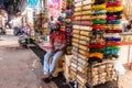 A street vendor selling colourful bangles and jewelry at his roadside store in the market in