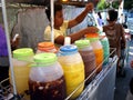 A street vendor sells a variety of fruit juice and other refreshments on his beverage cart at a street in Antipolo City.